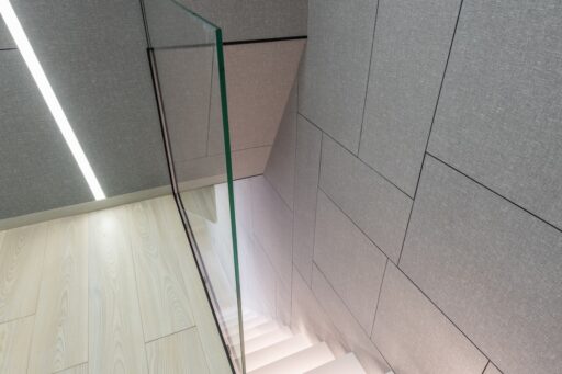 Iluminat scări - motivul pentru care iluminarea scărilor are un impact pozitiv asupra designului casei tale- scari albe luminate, balustrada de sticla-min, led-zone.ro