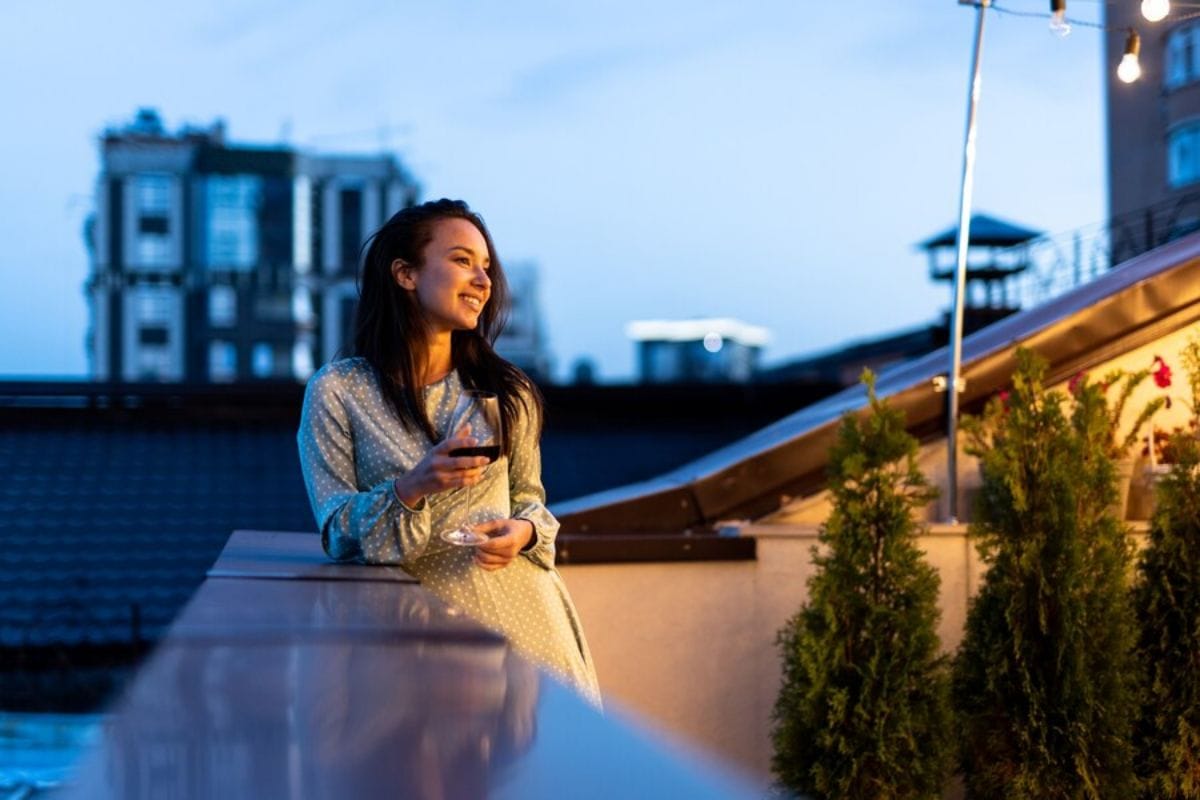 Iluminatul balconului - idei pentru iluminarea balconului și transformarea acestuia într-o oază de relaxare 1 Iluminatul balconului - idei pentru transformarea balconului intr-o oaza de relaxare_Femeie care se relaxeaza pe balconul iluminat, led-zone.ro
